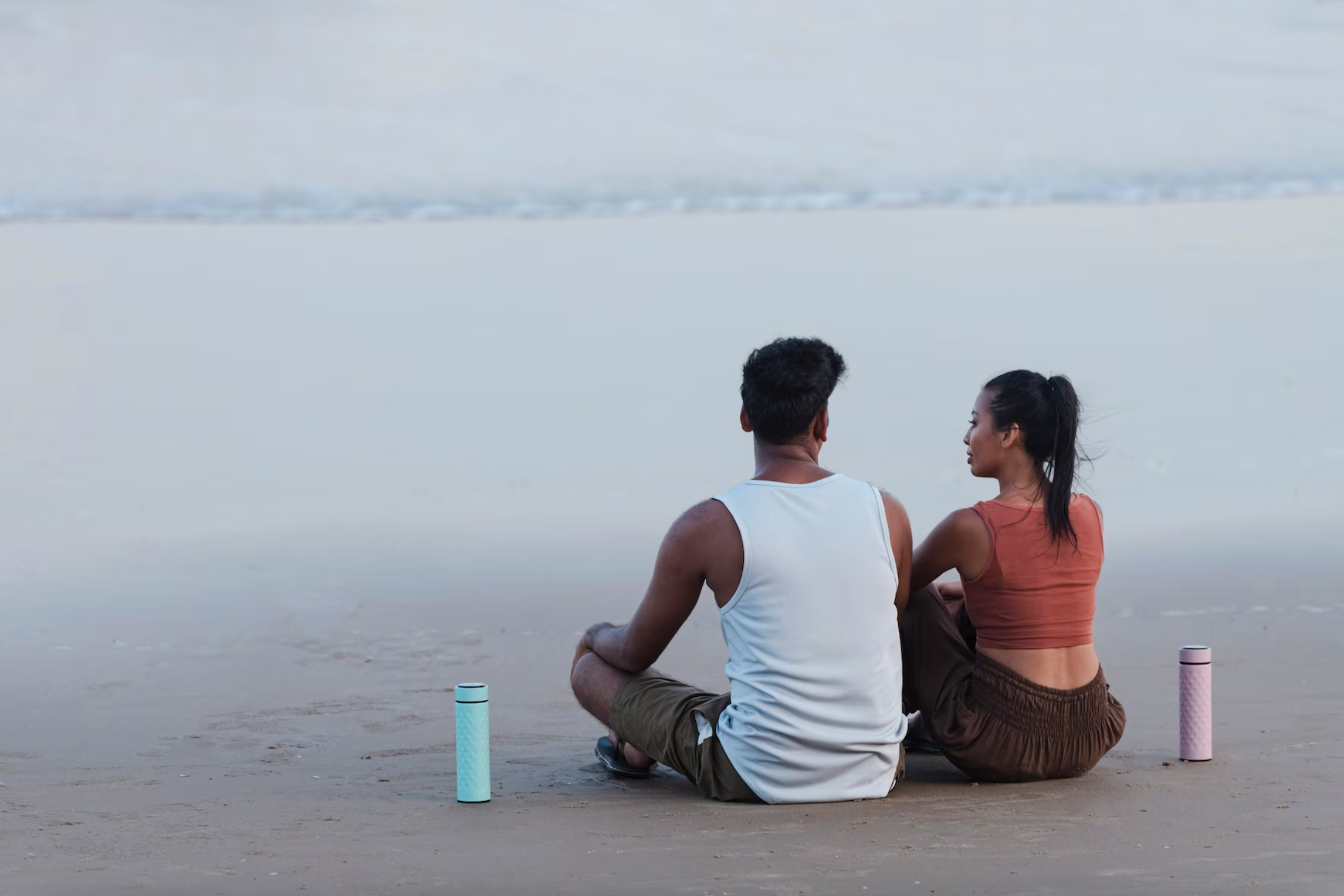 couple meditating on beach